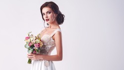 Young attractive bride with the bouquet of white roses