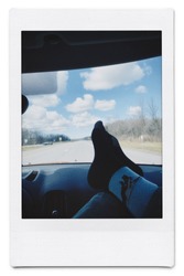 Feet on dashboard of car on highway