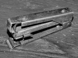 Old rusty stapler on a black and white background close-up