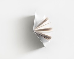 Open book with soft shadow on white paper background.