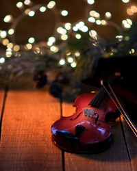 Exposition of violin and background with Christmas tree with light, very beautiful composition, the best day in the year. 