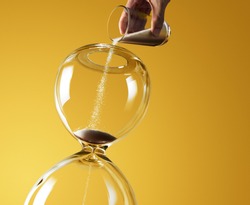 Deadline extended represented by pouring more sand into hourglass