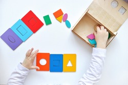 Learning colors and shapes. Children's wooden toy. The child collects a sorter. Educational logic toys for kid's. Kindergarten educational toys, Cognitive skills, Learn Through Play tools concept.