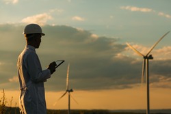 Engineer checks Wind Turbine system with a tablet. Alternative Energy. Wind farm. Clean renewable energy technologies. Wind power plants