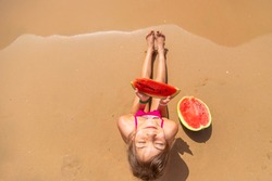 Child girl eats watermelon by the sea. Selective focus. Kid.