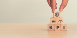 KPI, Key Performance Indicator. Businessman holds cube with KPI icon; business goals, performance results and indicators . For business planning and measure success, target achievement. Copy space.