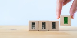 Green and eco building concept. LEED certification. Leadership in Energy and Environmental Design. Sustainable building. Hand holds the wooden cubes with green building symbols on white background.