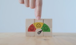 Customer feedback, service rating, satisfaction, customer experience concept. Evaluation for improvement product and service. Hand puts wooden cubes with emotions satisfaction meter icons.