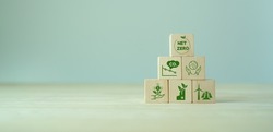 Net zero and carbon neutral concept. Net zero greenhouse gas emissions target. Climate neutral long term strategy. The wooden cubes with green net zero icon and save world icon on grey background. LCA