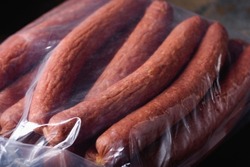Smoked Meat Sausages in Vacuum Packing. Snacks for Beer close-up. Ready Food. Finished Products