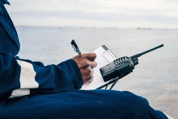 Seaman onboard a ship fills checklist. Paperwork at sea,