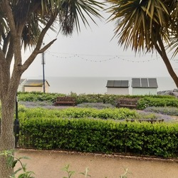 Felixstowe beach promenade with wooden beach huts  and seafront gardens during rainy cloudy May day in Felixstowe, Suffolk, East Anglia, England, united Kingdom, Europe 