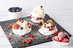 Meringue cake with fresh strawberries and blueberries. Cake Anna Pavlova. Close up.