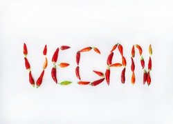 concept of vegan eating presented by the word made from red chili peppers on the white background