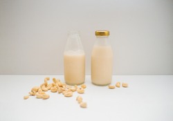 concept of eco living presented by plant based milk made from cashew in glass bottles