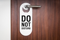 Door of hotel room with sign please do not disturb