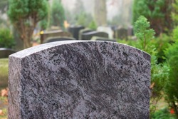 Blank granite tombstone without inscription; other tombstones in the background