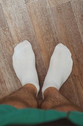 Hairy male legs on the floor in short white socks