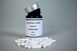 Vial of antiviral Coronavirus COVID-19 drug. Pills scattered out of the bottle. Coronavirus Covid 19 medicament for infection treatment against covid19. Healthcare and medical concept.