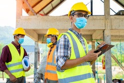 Team engineers and  builders having wearing protective masks to prevent dust and covid 19 disease during the inspection in construction site,Coronavirus has turned into a global emergency.