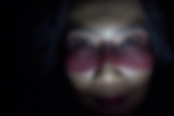 gaussian blur image of asian woman face with excessive eye make up 