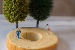 Gaussian blurred image of toy photography of miniature people jogging on cake 