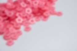 gaussian blur of pink sakura shape garment buttons for background 