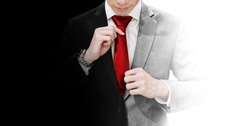 Businessman in blank and white suit holding red necktie