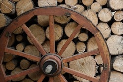 Retro wheel photo. Pieces of wood and wagon wheel. Old cart wheels .Vintage wooden carriage wheel,  wood background. Old wooden carriage wheel hanging on the barn