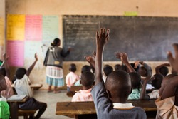 Happy students at a school in Uganda, Africa.  Students raising their hands.