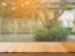 Wood table top on rain drops on clear window - can be used for display or montage your products