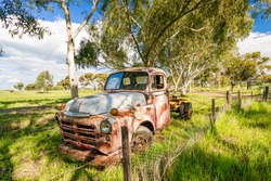 An old rusted out abandoned truck rests on the roadside near the country town of York, Western Australia, Australia.