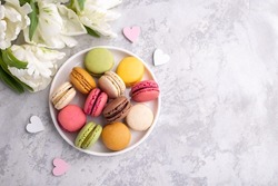 Colorful french macarons on grey stone background traditional dessert in France
