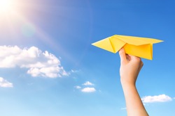 paper travel sky plane child flying yellow fun human leisure kid throw view throwing handmade freedom object up air airline joy concept - stock image