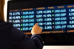 Computer monitor with currency exchange rates. Woman points her finger at the monitor. Currencies like usd, EUR, GBP, JPY and CHF on the screen. Banking, busines, trading, exchange and investment.