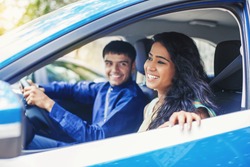 Beautiful Indian woman riding in a blue car with a driver