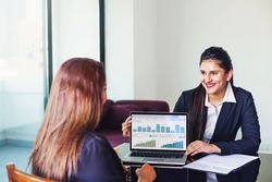 Investment consultant - Indian woman in formal suit, showing fund performance report with graphs on the laptop screen