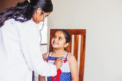 Cute Indian little girl being examined by paediatric doctor