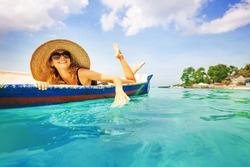 woman paddling in a boat in a paradise island