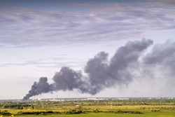 Images of smoke against the sky from a fire in the city on the horizon.