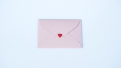 Pink paper envelope with Valentines hearts on white background. Flat lay, top view. Romantic love letter for Valentine's day concept.                               