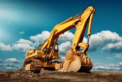 Large excavator on construction site on a sunny day with blue sky and fluffy clouds, cool modern look