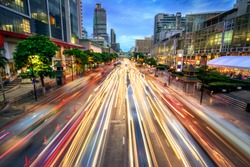 Busy street in the city at dusk, full of car light streaks; dynamic blue hour shot with long exposure motion blur effect