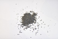 View of the circular steel grits on the paper for abrasive or sandblasting. Steel grits are produced by fracturing high carbon steel balls after heat treatment steel grits have high resistance
