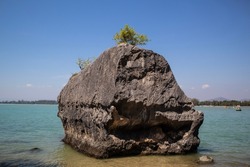 Black-gray mountain rocks on the edge of the shore overlooking the natural turquoise sea