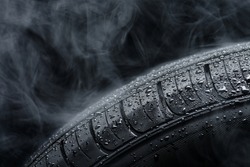 Car tire covered with water drops in the fog