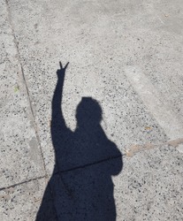 The shadow of the standing woman raises two fingers