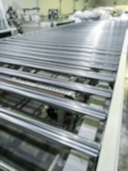 Blurred image of Slide rails transport the mattress to the production line in the factory.
