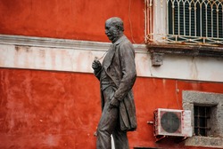 Statue of the economist and politician Antonio Scialoja (1817-1877) in Martyrs' Square, on a red background, Procida island, province of Naples, Italy