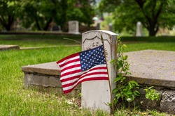 US flag on grave in cemetery 